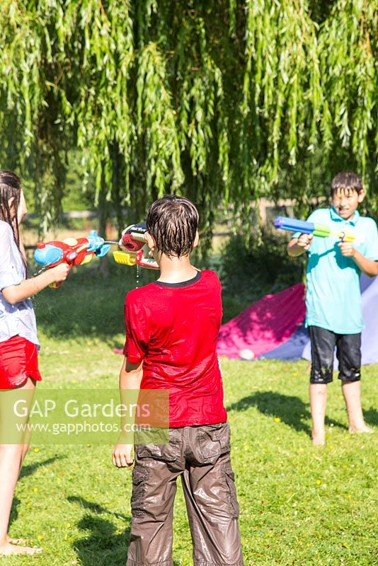 Children having a water fight in the garden