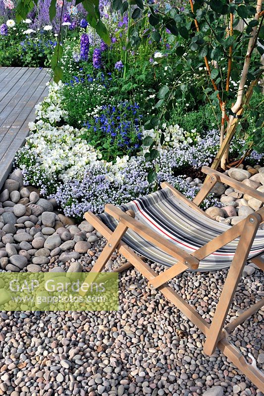 Deck chair in pebble and gravel border. A Day at The Seaside RHS Tatton Park Flower Show 2013