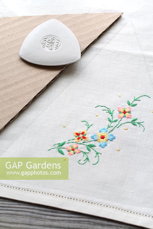 Step by step of making garden bunting with vintage linens and buttons - Using tailor's chalk and using the triangular template, mark out your traingles