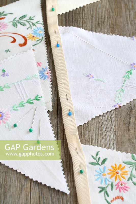 Step by step of making garden bunting with vintage linens and buttons - Pin the triangles up inside the fold of the ironed webbing