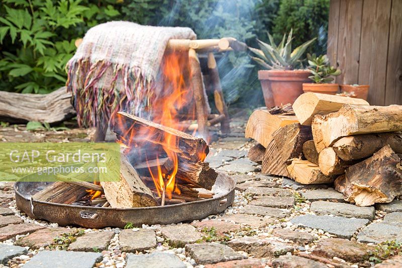 Firepit made from a dustbin lid with surrounding seating area