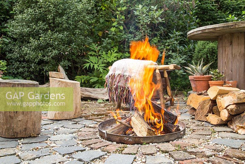 Firepit made from a dustbin lid with surrounding seating area