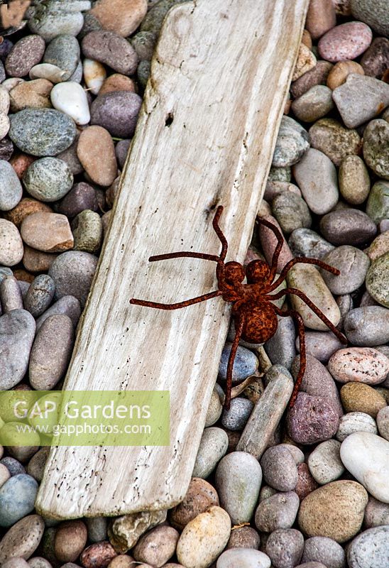 Spider sculpure on gravel and driftwood, Driftwood garden