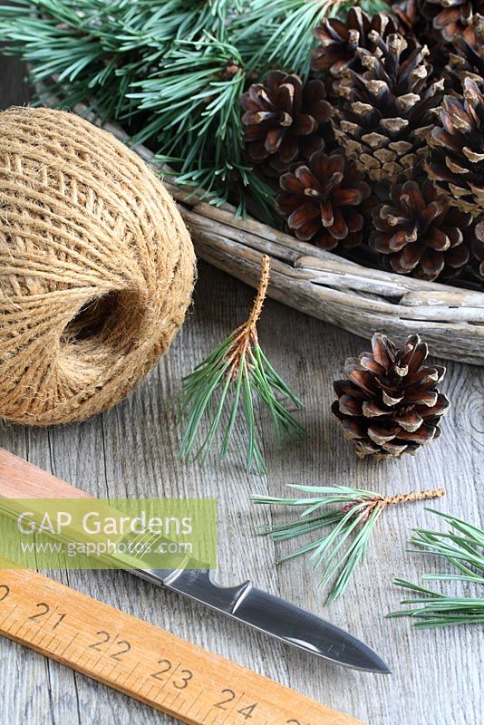 Step by step of making a simple, rustic Christmas garland with fir cones and pine needles - All materials -  fir cones, pine needle sprigs, penknife, twine and ruler