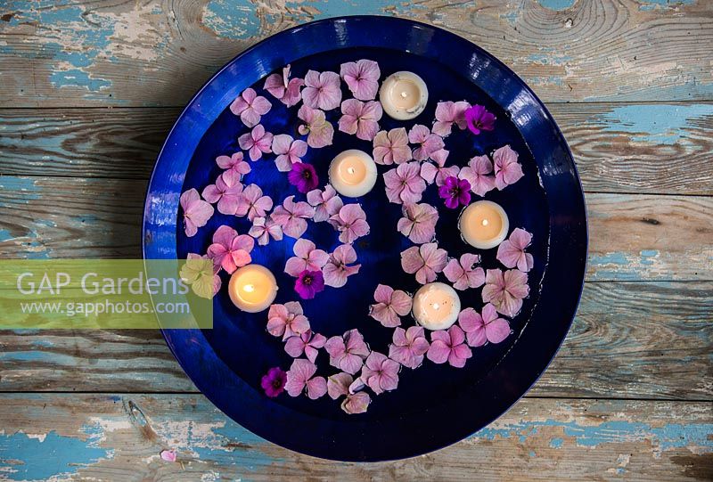Floating candles accompanied by Hydrangea and Geranium flowers