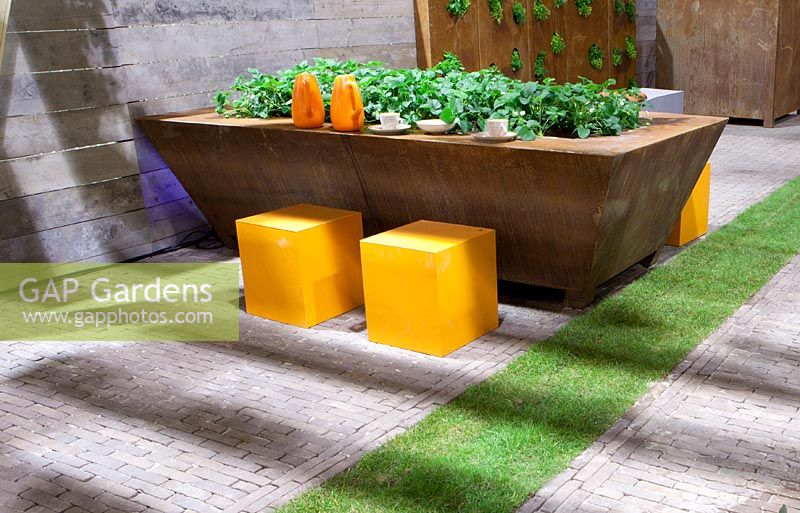 Vegetable garden in metal container also used as table.