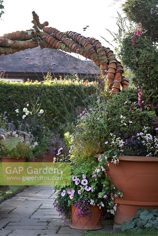 Whichford Pottery entrance. Geranium, fushia, lobelia, dahlia, verbana bonariensis and petunia in large terracotta pot.  
