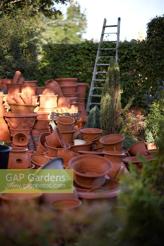 Whichford Pottery.  Pile of hand thrown terracotta pots in the morning sun.