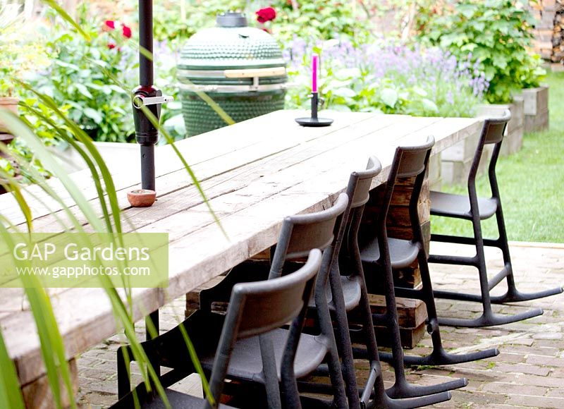 Long table made of recycled wooden boards. Black rocking chairs from IKEA 