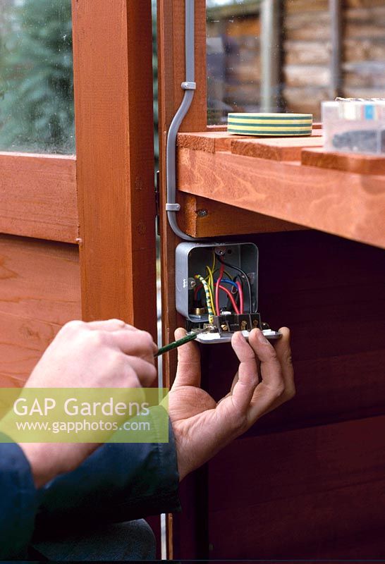 Electrical wiring in greenhouse - connecting armoured supply cable into switch together with extension wiring for lights and socket 