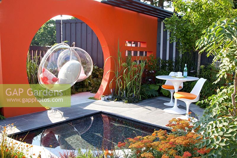 Furniture in modern garden with retro designer furniture - planting includes, Achillea Terracotta, Ginkgo biloba