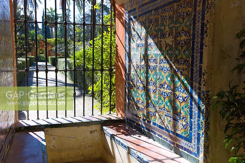 Azulejos tile decoration around a seat in the gardens of the Real Alcazar, Seville, Andalusia, Spain