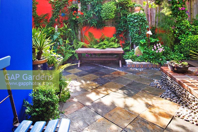Small town garden with slate tiled floor inset with pebbles 