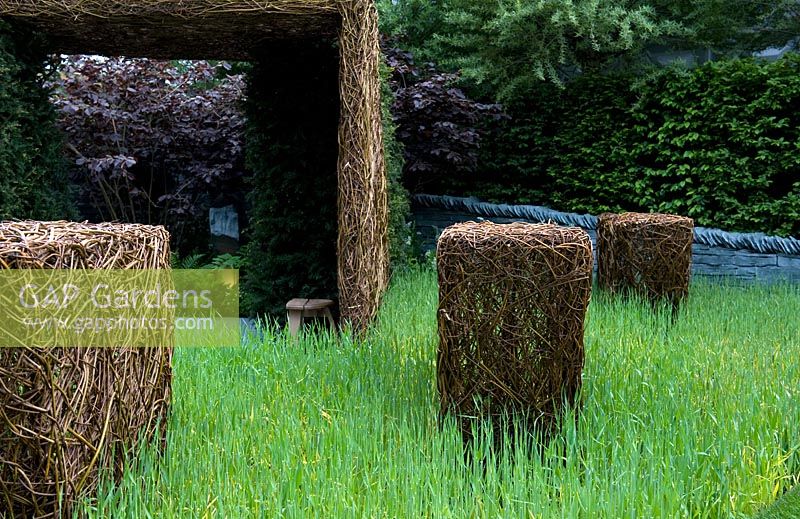 Stockton Drilling as Nature Intended Garden, Silver gilt medal winner, Chelsea Flower Show 2013. Woven willow sculptures in long grass
