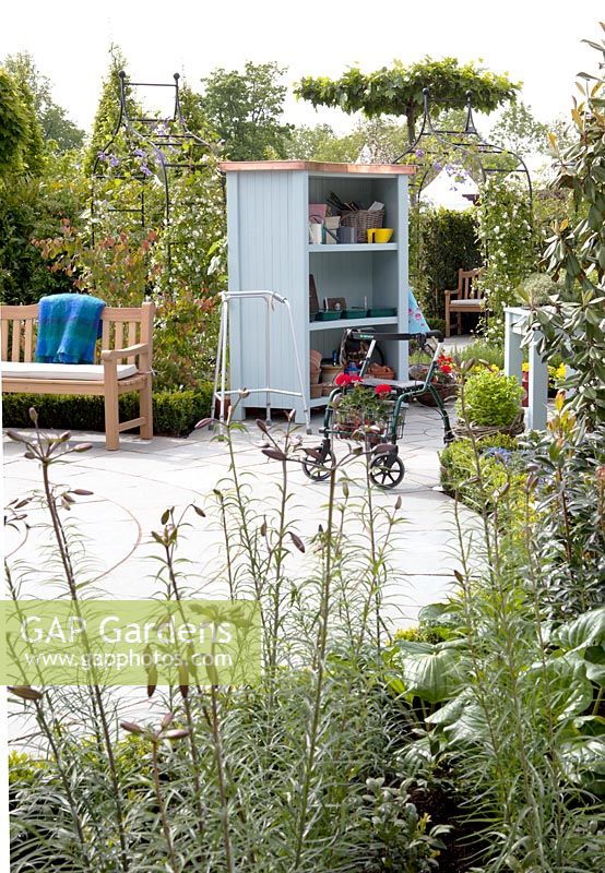 Garden with shed for gardening tools and pots.