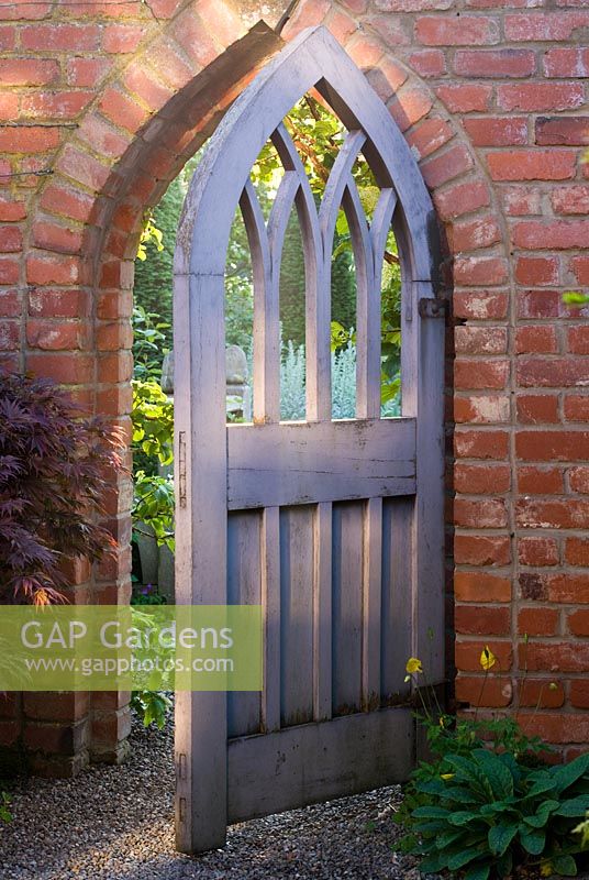 Gothic style wooden gate leading to yew walk 