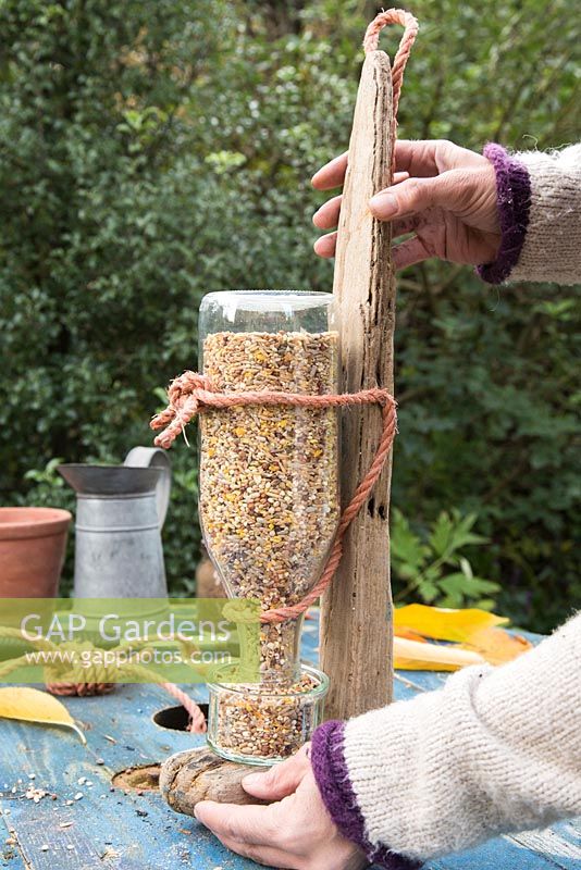 Standing Bird Feeder upright to empty seeds into bowl