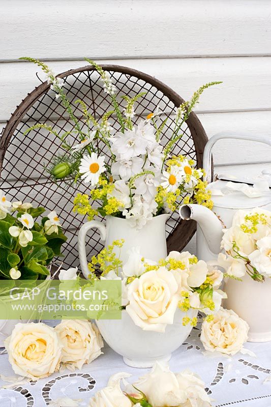 White-themed summer floral arrangement - roses, alchemilla mollis, linaria, delphinium, margerites, begonia, sweet peas