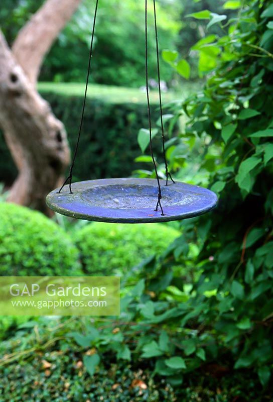 Decorative bird table made from old plate. The garden of Swedish garden designer and editor Ulla Molin 1909-1997 in Hoganas, Sweden, in 2005.
