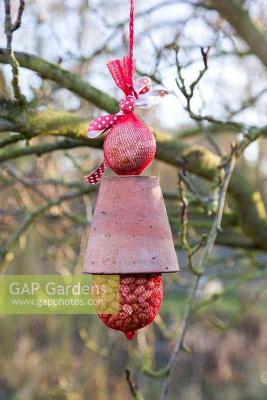 Birdfeeder made from a Terracotta pot, bag of peanuts and ball of bird feed