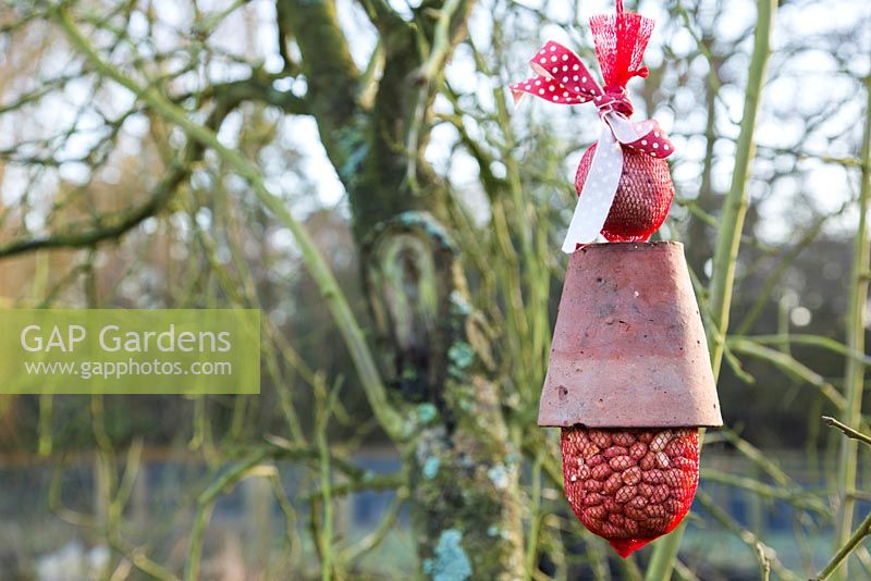 Birdfeeder made from a Terracotta pot, bag of peanuts and ball of bird feed
