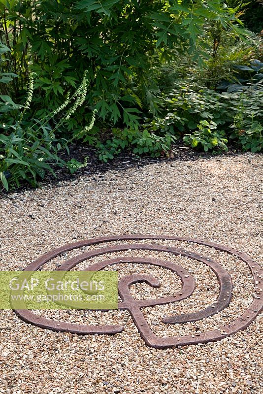 Decorative metal feature on ground in gravel in Rust Garden