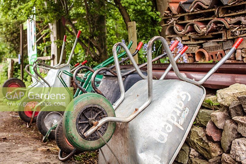 Wheelbarrows lined up with insect habitat in the background, Windmill Hill City Farm, Bristol