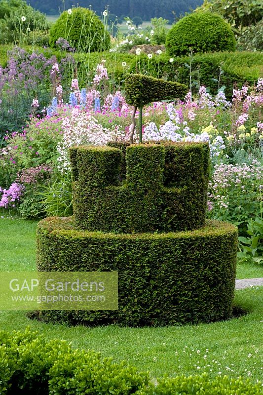 Yew topiary castellated with perennial border 