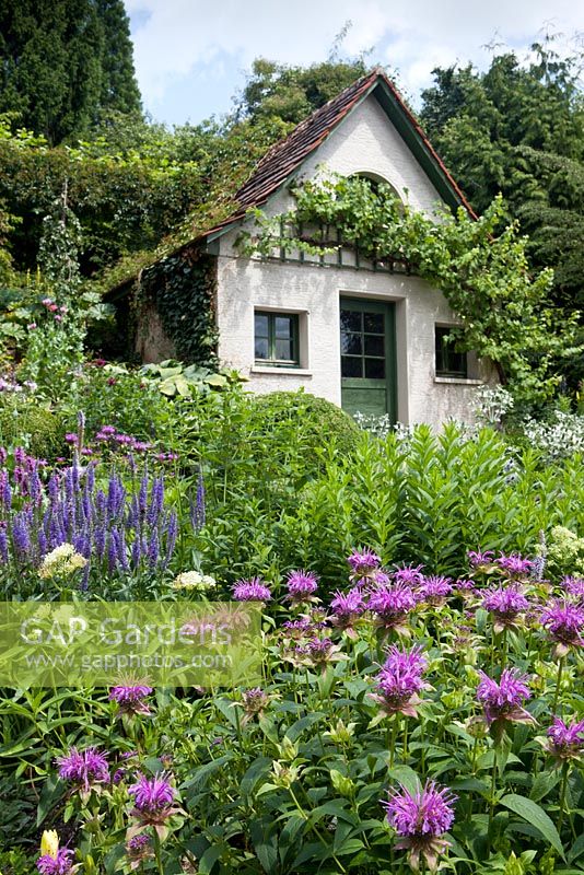 Summer house with planting of Stachys officinalis, Veronica spicata, Asclepia, Monarda menthifolia, Buxus sempervirens