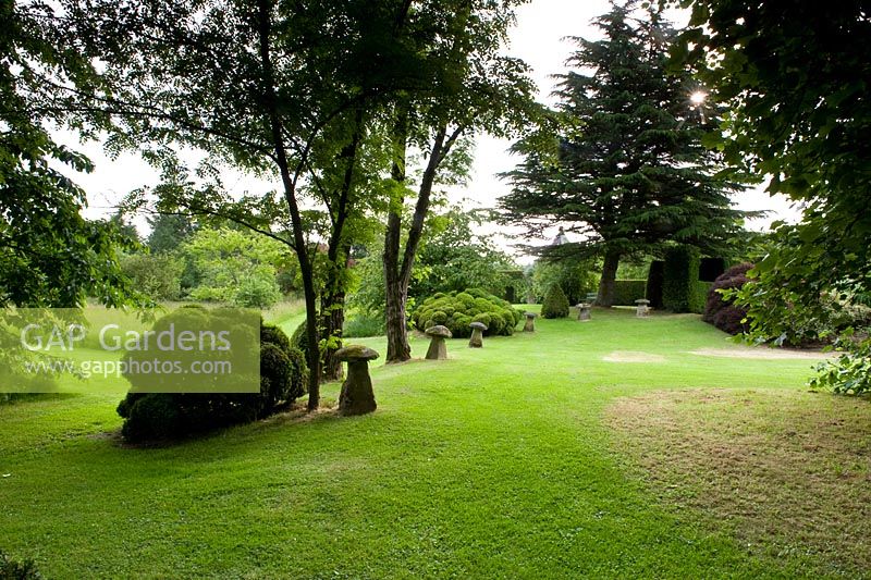 Cothay Manor, Greenham, Somerset. Lawn with trees and shrubs