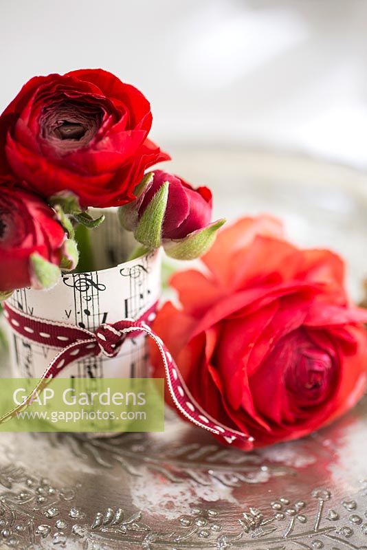 Floral display of Ranunculus wrapped in music sheet paper
