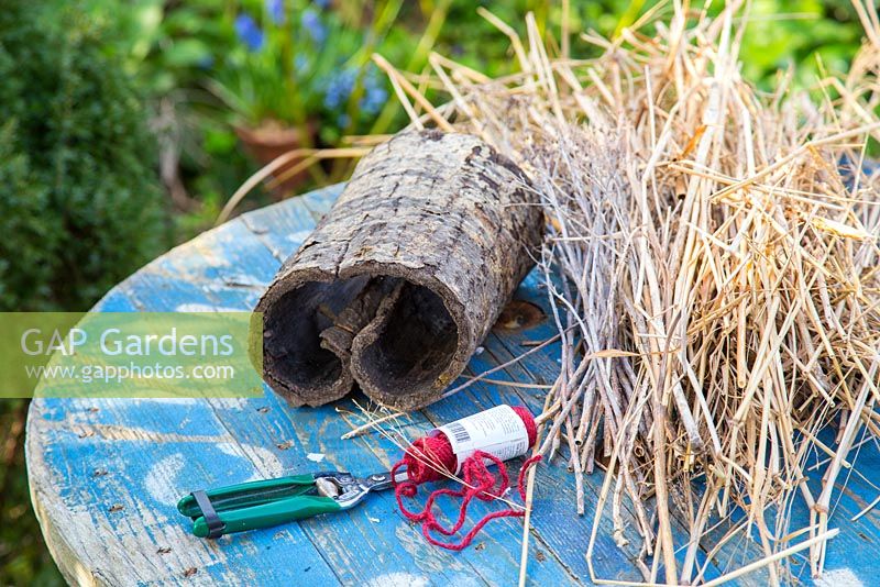 Materials needed are string, bark and straw on garden table 