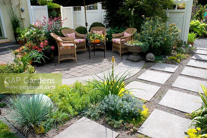 Seating area on Patio with a variety of potted plants.
