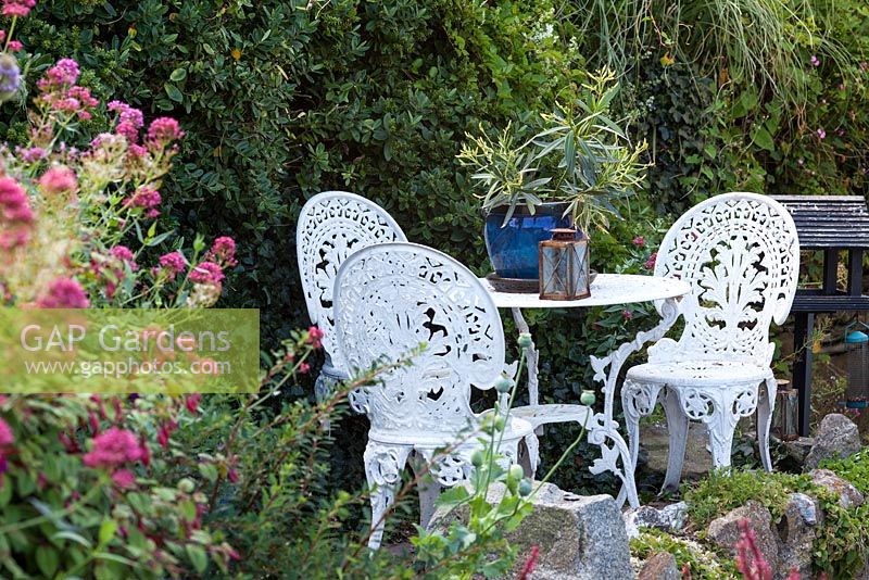 Elegant metal table and chairs in coastal garden 