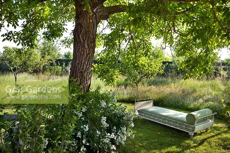 Daybed in the shade of fruit trees in the orchard at Borgo Santo Pietro, Tuscany