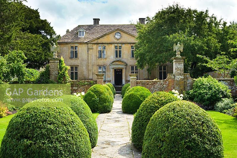 Tintinhull Court, Somerset. View of house and gardens with box topiary