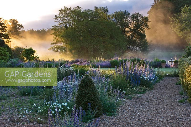 Dawn light on the river nar and the gravel garden in front of the hall. Narborough Hall Gardens, Norfolk