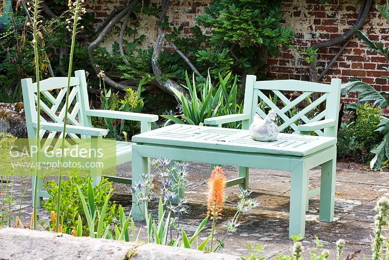 Green painted wooden bench and chairs on patio. Sandhill Farm House, Hampshire