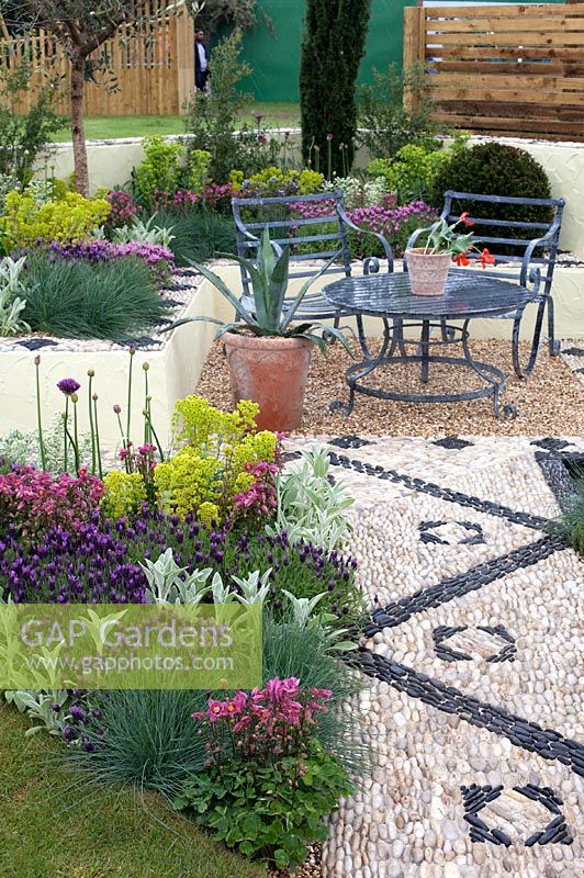 Seating area with mosaic surfaces and colourful flowerbeds - 