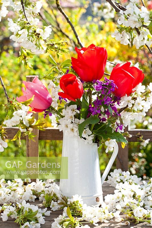 Floral display of spring flowers includes tulips, honesty and cherry.