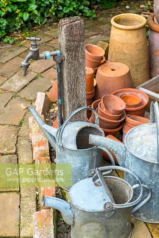 Garden standpipe with galvanised watering cans.