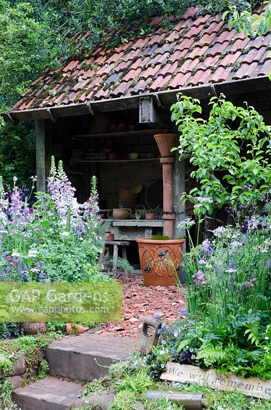 Potting shed with cottage style planting. Dial A Flight, RHS Chelsea Flower Show 2014. 