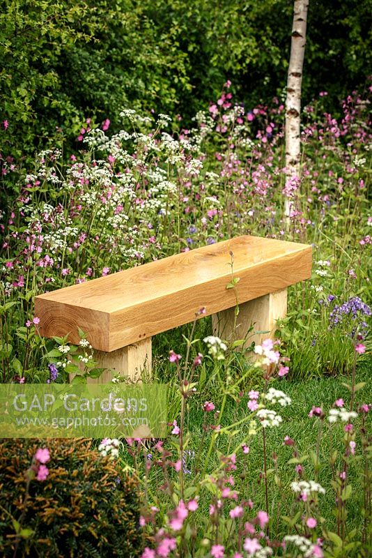 Wooden bench amongst Anthriscus sylvestris - Cow Parsley, Silene dioica - Red Champion and Hyacinthoides non-scripta - Bluebell, 'Bringing Nature Home', show garden, RHS Malvern Spring Festival 2014