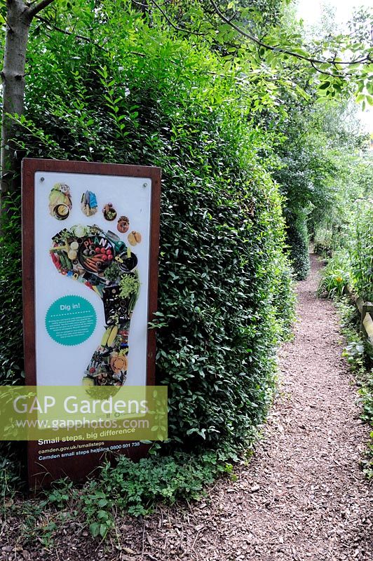 Food growing poster or notice board alongside path encouraging people to grow food and reduce their footprint on the earth, Camley Street Natural Park, London Borough of Camden