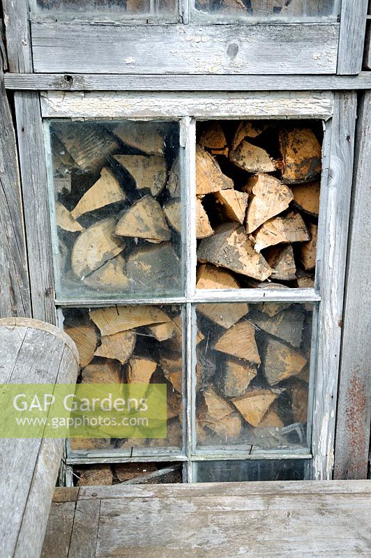 Logs of wood seen through window of allotment shed or hut, Golf Course Allotments, London Borough of Haringey