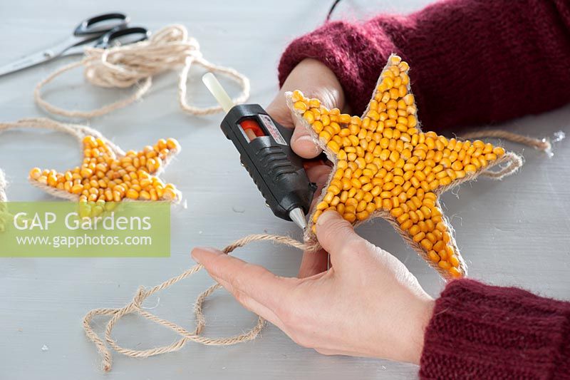 Making homemade Christmas tree ornaments ​​from corn -  glueing on string
