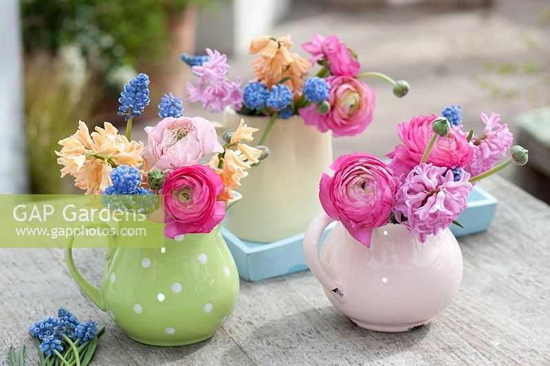 Colourful display of cut flowers in ceramic jugs 