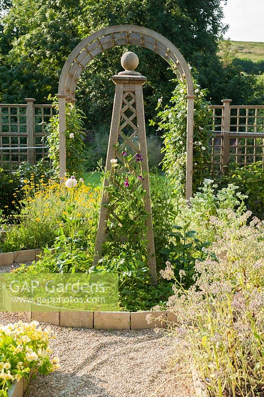 Decorative potager with wooden obelisk at its centre. Old Rectory, Batcombe, Somerset, UK