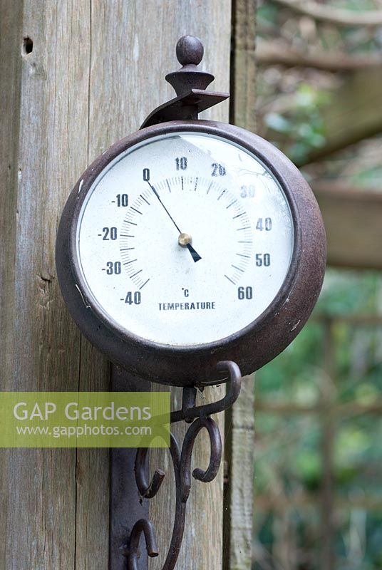 Outdoor wall hanging thermometer showing freezing