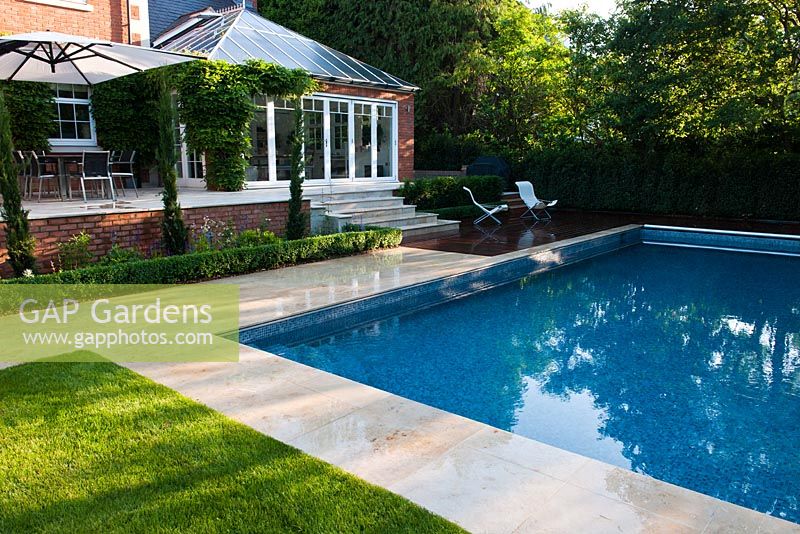 Modern split level garden with pool and conservatory 
